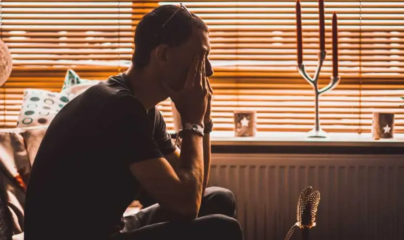 Man met handen voor ogen