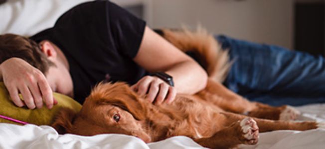 man op bed met hond