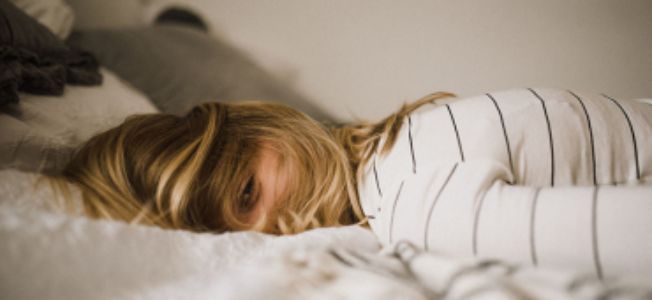 Vrouw op bed met oog open