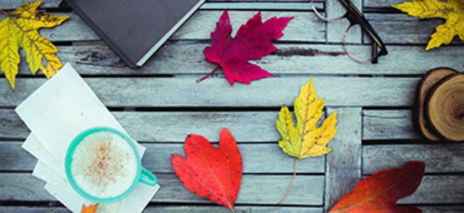 tafel met herfstbladeren en notitieboek